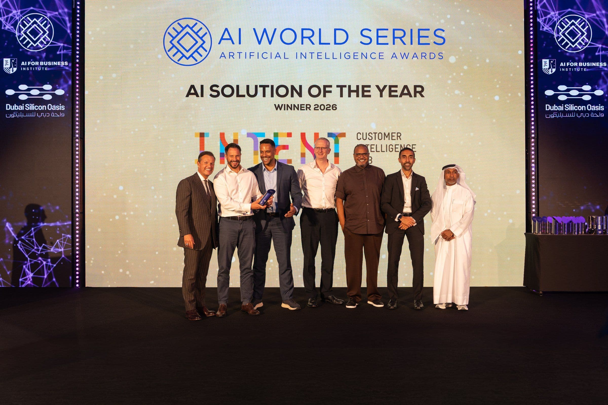 The Intent HQ team on stage at the AI World Series Awards in Dubai, holding the trophy beneath a screen that reads AI Solution of the Year, Winner 2026.